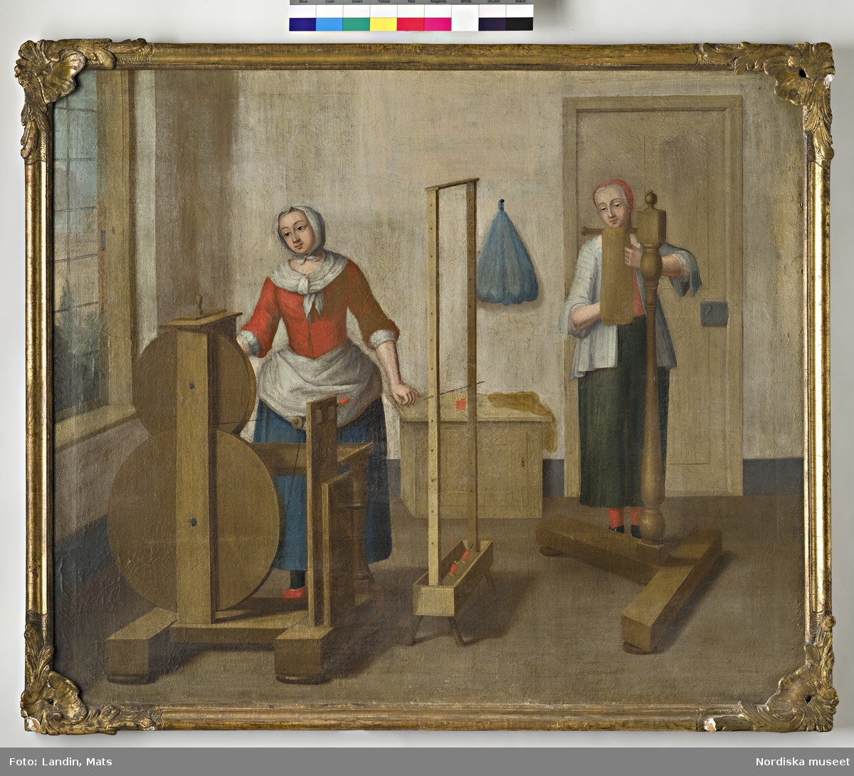 Oljemålning. Scener från ett silkespinneri under 1700-talet. Tvinning och härvutredning. Två kvinnliga figurer. Har tillhört sidenfabrikör Rudolf Stenberg, Stockholm.