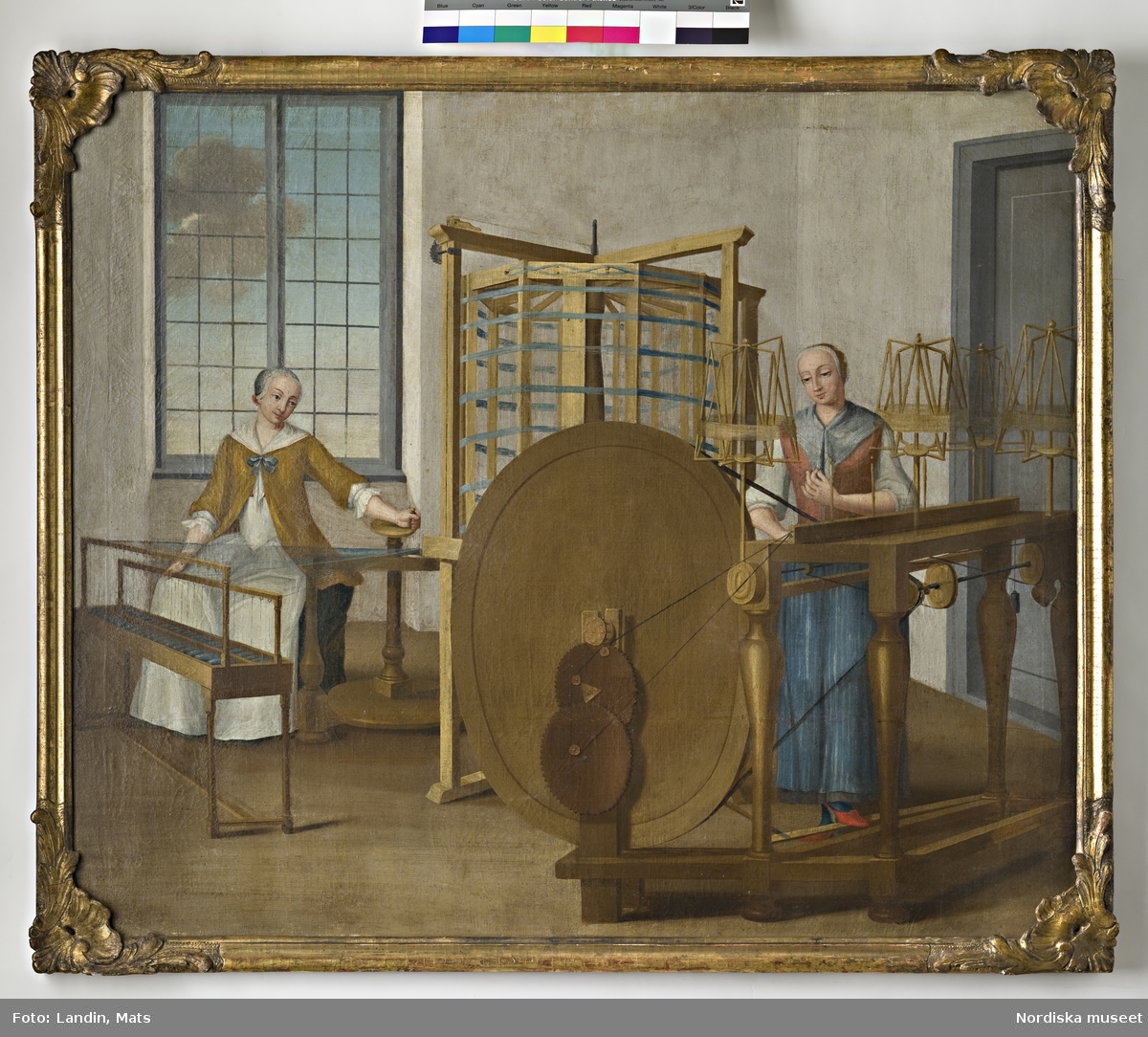 Oljemålning. Scener från ett silkespinneri under 1700-talet. Varpning och tvinning. Två kvinnliga figurer. Har tillhört sidenfabrikör Rudolf Stenberg, Stockholm.