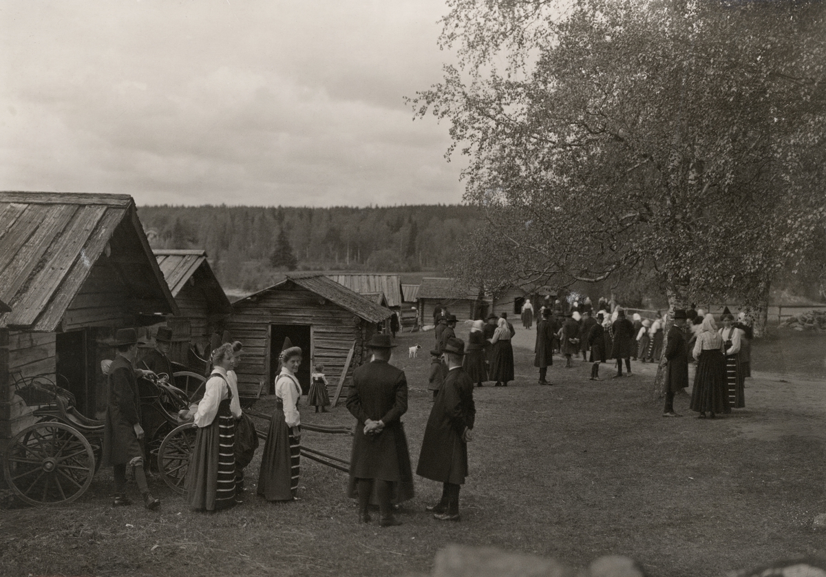 Högtidsklädda människor samlade utanför kyrkstallarna vid Rättviks kyrka i Dalarna