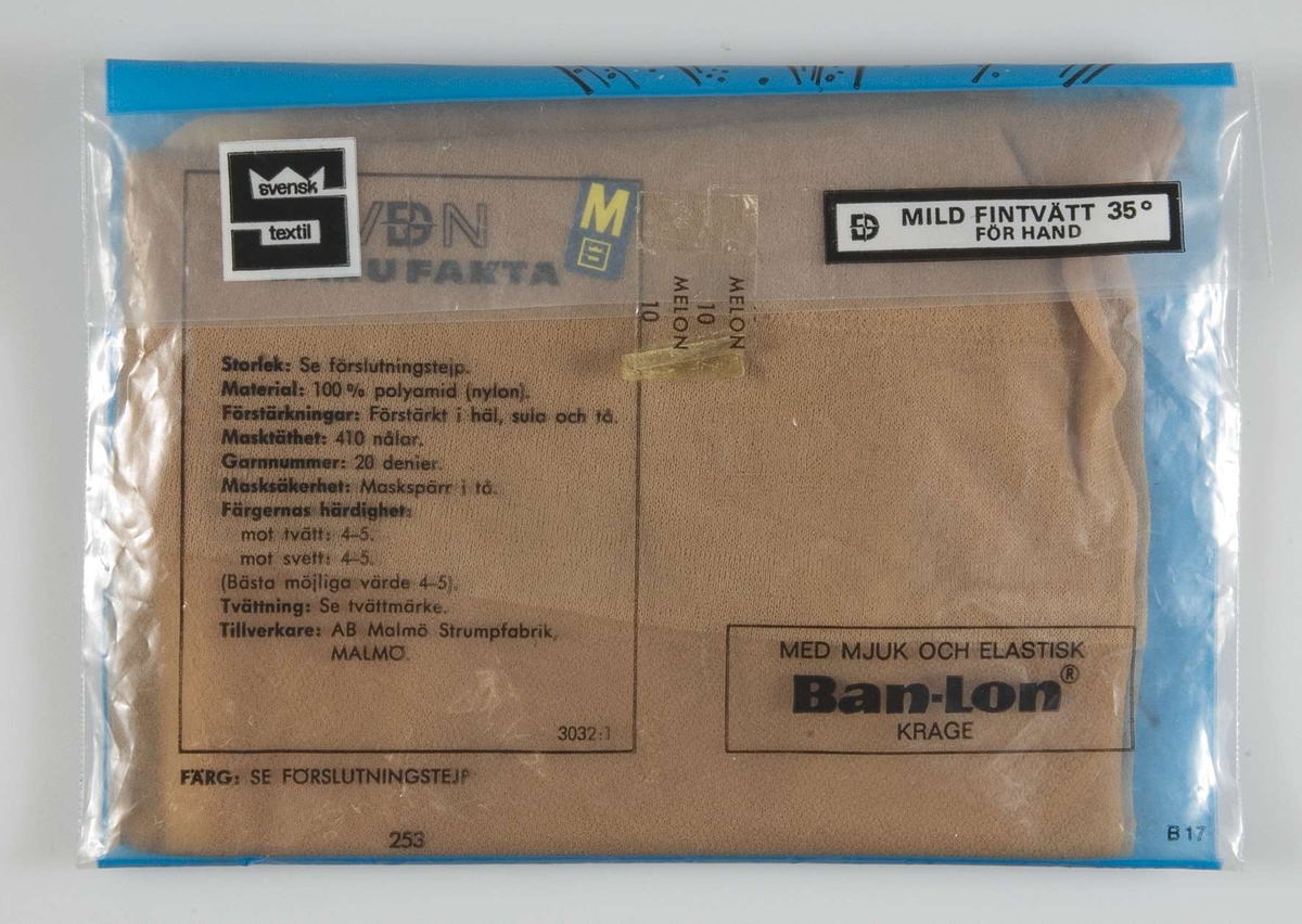 Ett par ljusblå nylonstrumpor i förpackning av plast. På baksidan av förpackningen texten: "Skönhetsfel III sort".