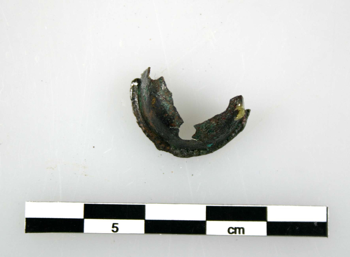 Fragment av bjällra, av brons. Ursprungligen rund, av två halvkupiga delar.