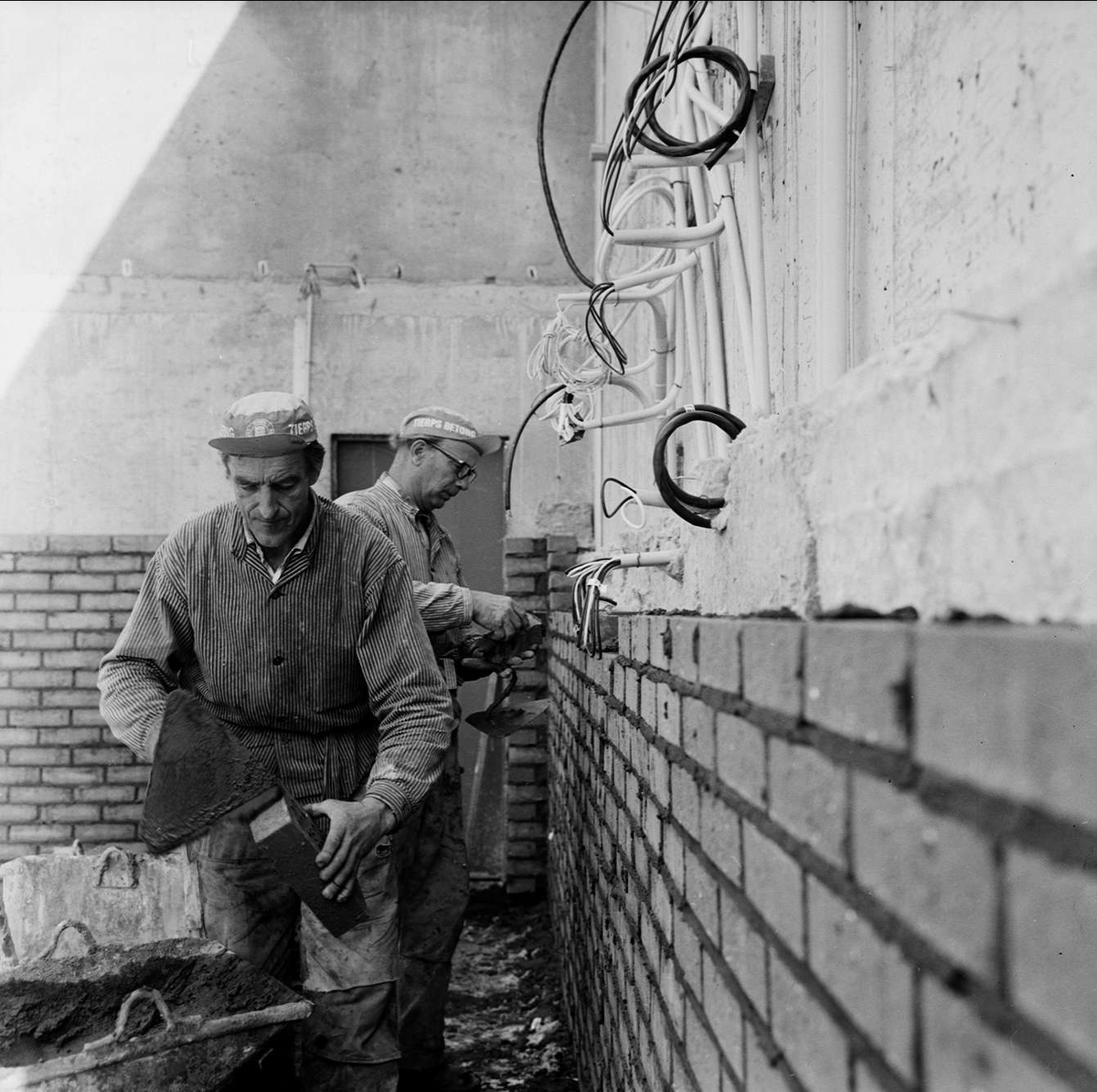 Kärvt för byggjobbare i Tierp, Uppland augusti 1972. Två män murar 