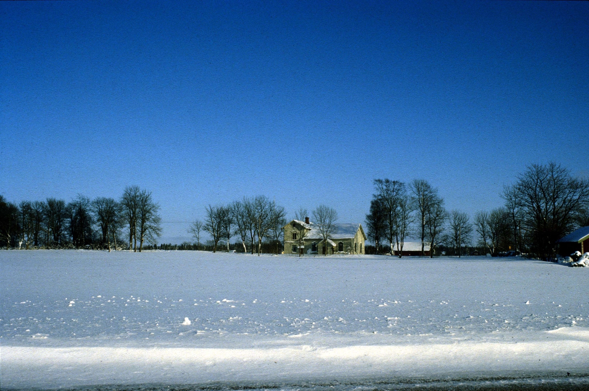 Vinterlandskap med Snesslinge missionskyrka, Börstils socken, Uppland 1984