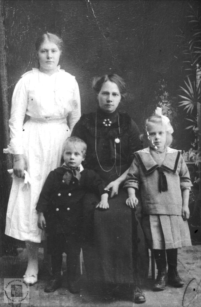 Portrett av ukjent mor med konfirmant og småbarn.