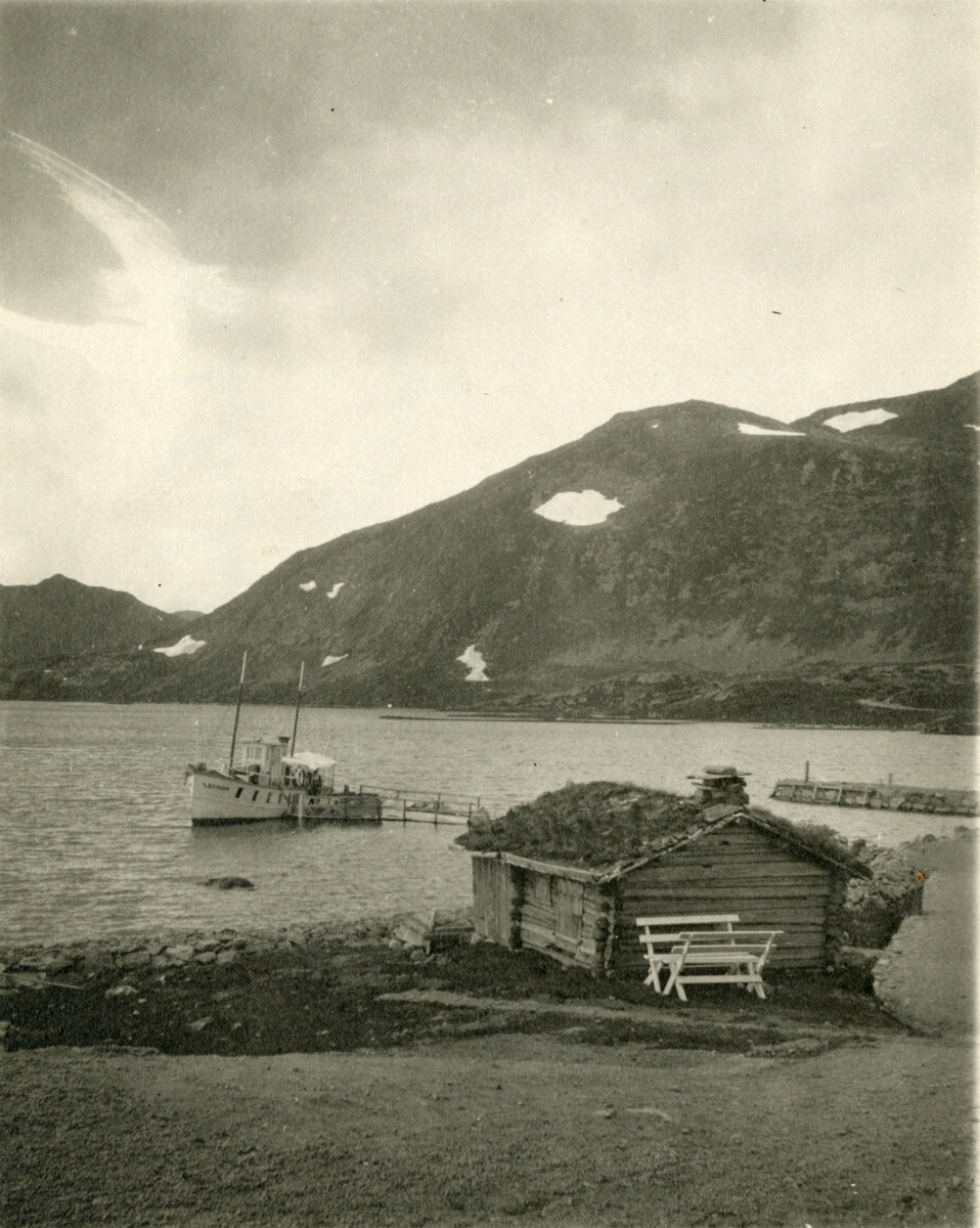 M/S 'Bitihorn' (b.1912, Glommens mek. Verksted, Kråkerøy, Fredrikstad), med koie, og fjell i bakgrunnen.
