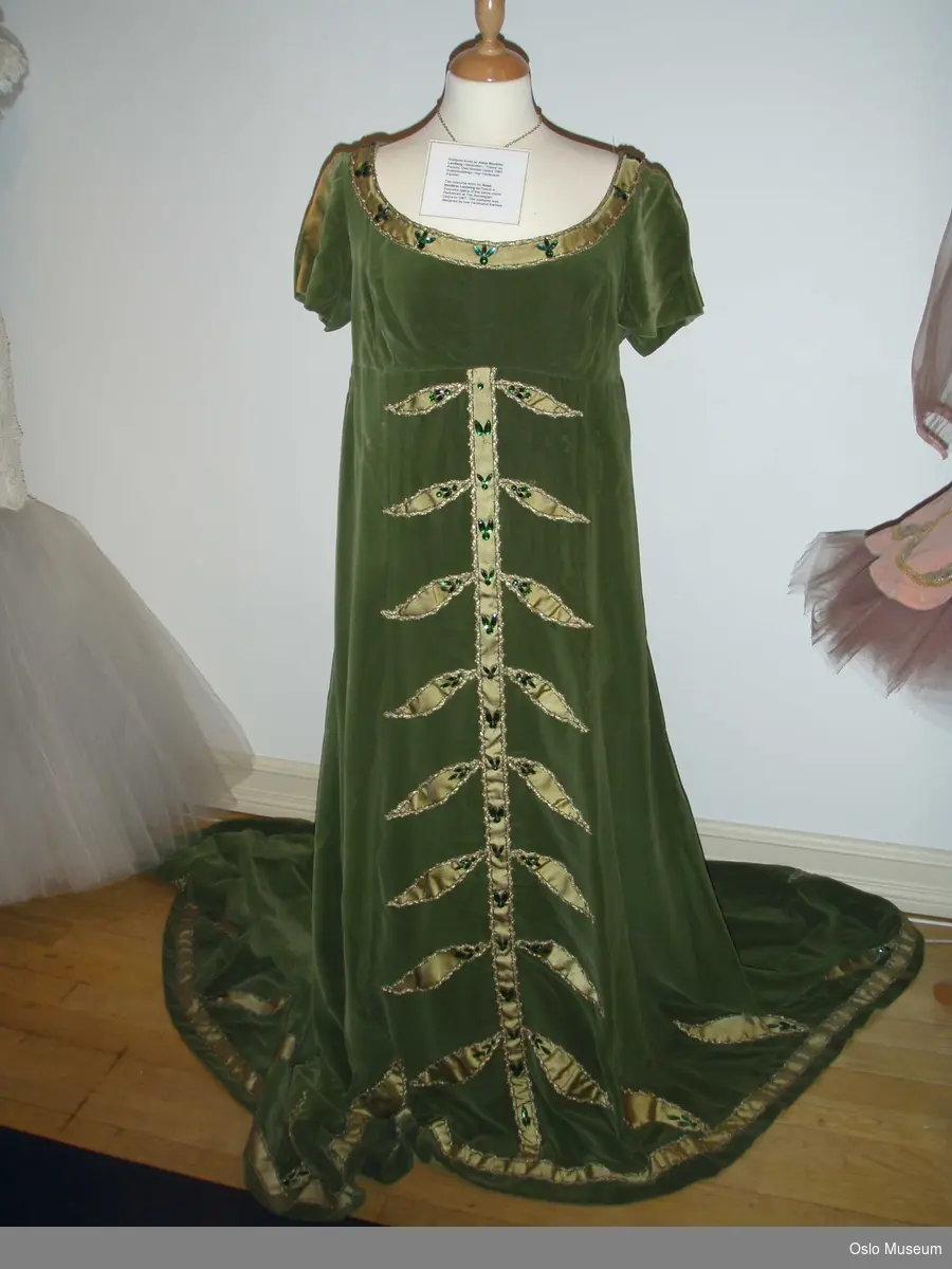 Kostyme, fotsid kjole i grønn fløyen med gullmønster og perler.