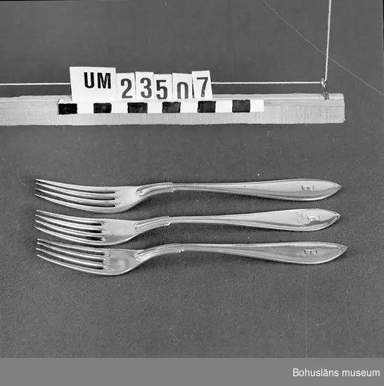 471 Tillverkningstid 1920-1950?
594 Landskap BOHUSLÄN

Svenska modellen. Instansat "B" för (Bokströms). En gaffel även med ingraverat "H.L". 
Ur uppsättning bordsilver för uthyrning.

Neg nr UM142:2.
