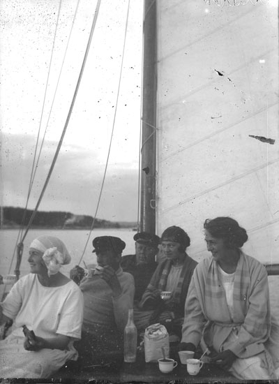 Enl. text i blå bok: "Fem personer i sittbrunnen på segelbåt."