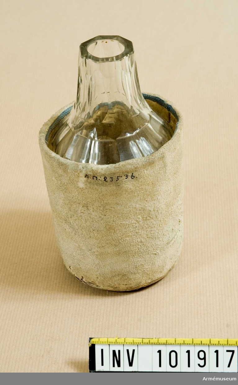 Flaska av slipat glas för nattvardsvin. Skyddsfodral av sämskskinn. Naturkork.