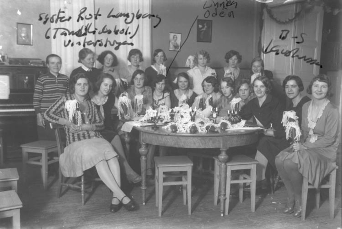 Kvinnor sitter runt ett bord i Vinterstugan och tillverkar pappersstrutar. Bakre raden: Berta Johansson (1), Syster Rut Langberg (2), Svea Björk (4), Lizzy Bard (6), Märta Björk (7). 
Främre raden från vänster Britt Nilsson (1), Ingvor Pettersson (2), Stina Roman (3), Lisbeth Ragnar (4)?, Greta Collin (6), Anna Greta Kjellin (7), Berta Nillson gift Ragnar (8), Astrid Salomonsson (9), ? Lisa Karlsson (10), Mildred Svensson (11).