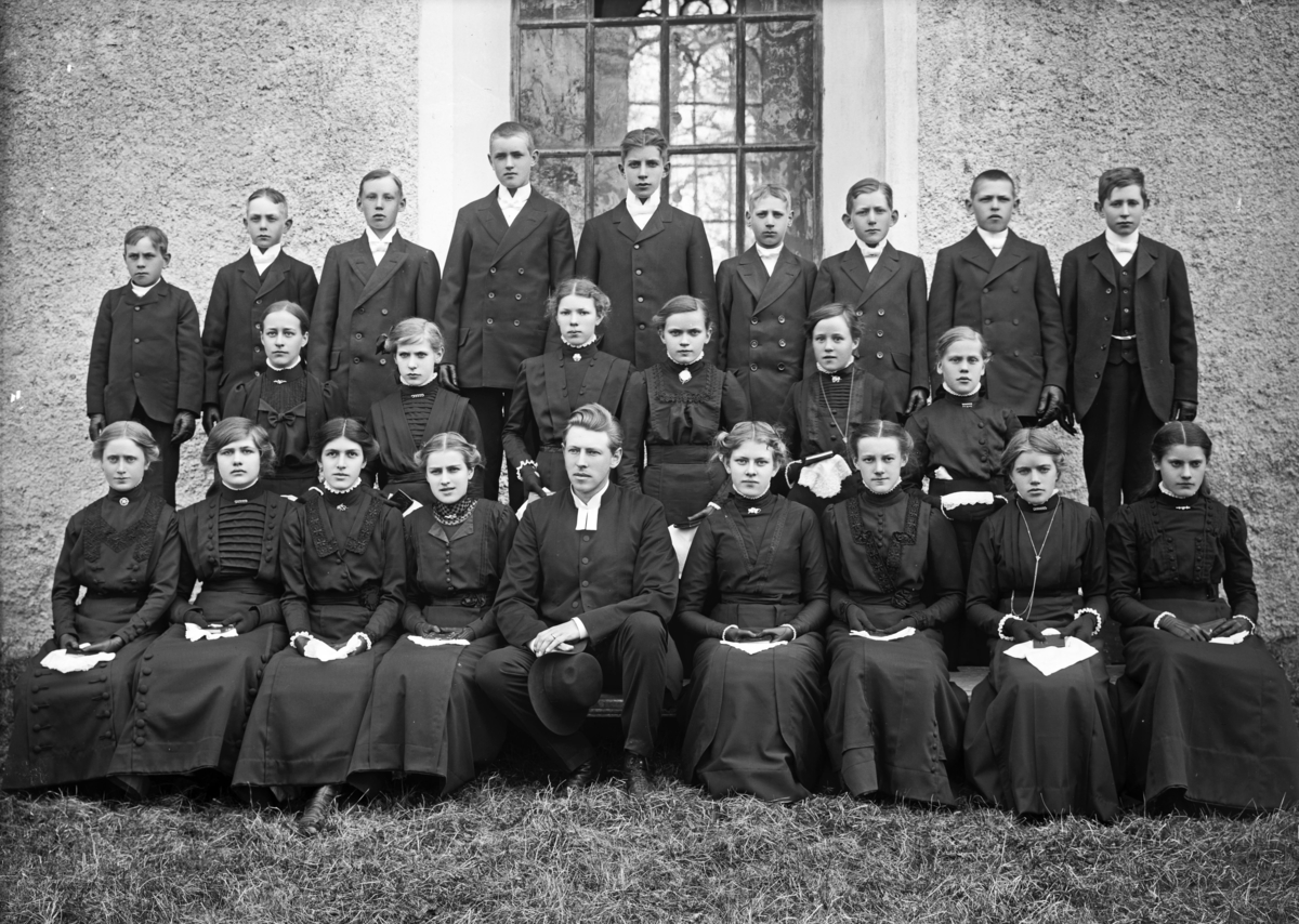 Konfirmandgrupp vid Veckholms kyrka, Uppland, 10 maj 1913. I mitten komminister Mats Åmark (1882-1973).