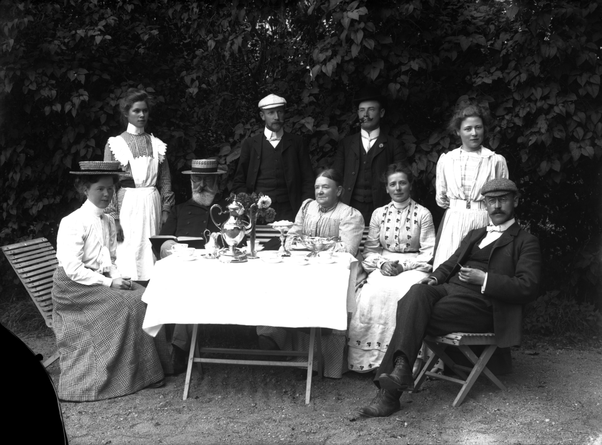 Grupp, sannolikt vid Sparrsätra prästgård, Sparrsätra socken, Uppland. Mannen i hatt t.v. kyrkoherde Anders Johan Norberg (1843-1914).