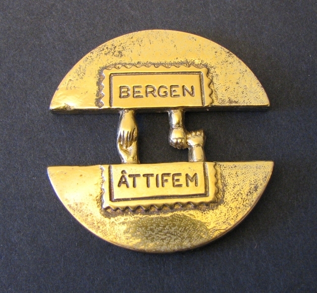 Medalj i form av två cirkelhalvor, sammanhållna av två
parhänder. Adversen visar ett stiliserat frimärke med texten
"BergenÅttifem". Reversen har ett streckmönster. På medaljens övre
kantinskriptionen "Postmuseum". Medaljen tilldelad Postmuseum
fördeltagande i utställningen Bergen 85.