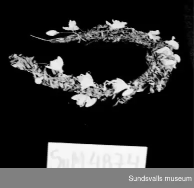 Diadem tillverkat av kvistar från myrten och vita konstgjorda blommor ihopknutna med svart sytråd och metalltråd.