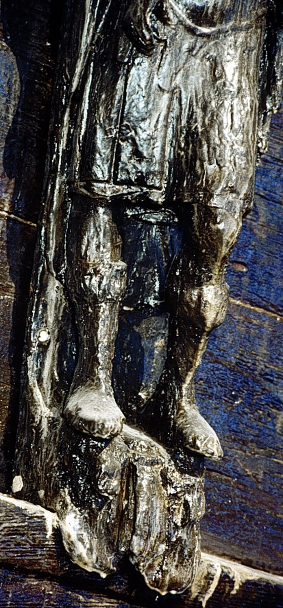 Skulptur föreställande en mansfigur. Ansiktet är slätrakat och på huvudet sitter en lagerkrans. Bakom huvudet ses ett stort snäckskal. Figuren är iförd en antik rustning av thoraxmodell. Manteln  är draperad snett över bröstet och hänger ned utmed ryggen. På höger axel är manteln fästad med ett spänne.
Figurens kropp är frontalt riktad, med huvudet vridet en aning mot höger. Kroppstyngden vilar på höger ben, medan vänster ben är böjt. Höger arm hålls något böjd snett framför höften, medan vänster arm hålls utefter sidan.



Figuren står på en kvadratisk sockel, vilken pryds av en maskaron. På vänster del av maskaronen, sett från betraktaren, finns en namninskription. Inskriptionen är oläslig så när som på bokstäverna D och O.



Upptill är bakstycket framdraget i en kraftig "huvudplatta", med en kvartscirkelformad profil. Skulpturens baksida uppvisar två fält i olika plan. Fälten, som utgör anliggningsytor, ger skulpturen en trappstegsformad profil.

Skulpturen är relativt välbevarad. Sockeln är dock kraftigt skadad, och kejsarfigurens vänstra underarm saknas.



Text in English: A sculpture representing a male figure. The laurel-wreathed head has a clean-shaven face and is backed by a large sea shell. The figure is wearing thorax armour with the mantle hanging down over the back and draped slantingly across the chest where it is fastened with a buckle on the right shoulder.



The figure''s body is posed frontally, the head turned slightly to the right. The body rests on the right leg while the left leg is bent. The right arm is held slightly out from the body while the left arm is held along its left side.



The figure stands on a rectangular plinth decorated with a mask. If the sculpture is viewed from the front the letters start on the left hand side and the first two, D followed by O, can be read.



The upper part of the back extends obliquely upwards in a powerful "head board". The back of the sculpture has two surfaces of different depths that are areas of attachment. The surfaces make the sculpture look like a step-ladder in profile.

The sculpture is rather well preserved, but the plinth is badly damaged. The figure''s right forearm is broken off.