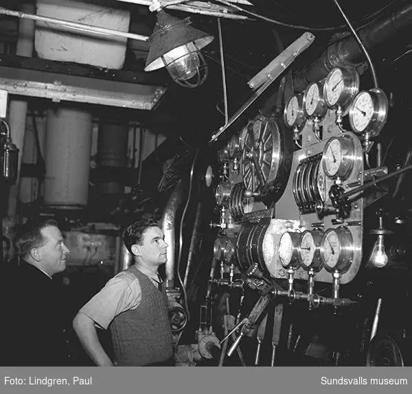 Tankfartyget Diplodon vid oljehamnen i Vindskärsvarv, dit den anlänt med bensin och brännoljor för Shell och Caltex. En serie reportagebilder med fartyg och manskap som arbetade på tankern.
Mt Diplodon var en engelsk tanker byggd 1941 för Anglo-Saxon Petroleum Co Ltd i London. Skrotad 1960 i Hongkong.