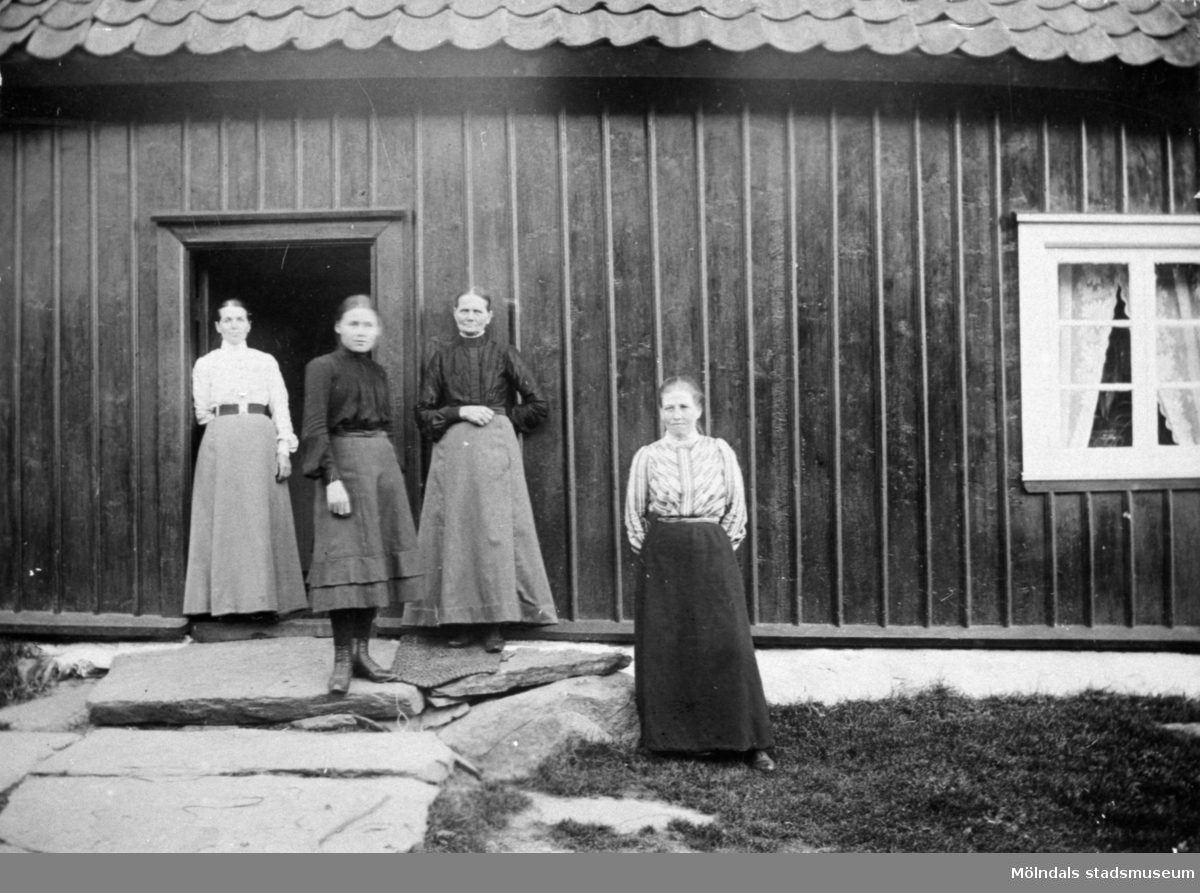 Från vänster står Josefina Eriksson, Valdeborg Johansson, Maria Eriksson och Anna Carlsson vid Olas stuga 1907 - 1910.
Text på baksidan av fotot: "Fr v. Fina, Valdeborg, Maria och Anna".  Anna arbetade som piga hos systrarna Maria och Josefina. De var moster till Valdeborg.
