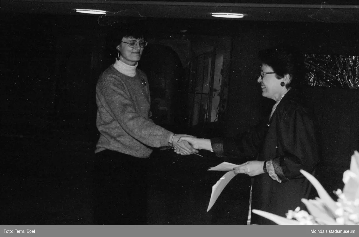 Prisutdelning i Mölndals stadshus vid tävling om Mölndals souvenirer i februari 1992. Konstintendent Bodil Magnusson, till vänster, vann andrapris. Den som delar ut blommorna är Kultur- och fritidsnämndens ordförande, Sonja Knutsson.