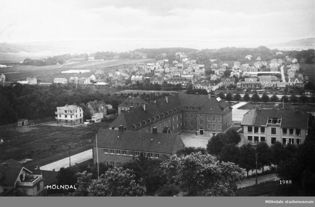 Vykort "Mölndal", postat den 8/7 1937. Utsikt från Störtfjället över Kvarnbyskolan (dåvarande Centralskolan) med gamla Trädgårdsskolan till höger och Mölndalsbroområdet.