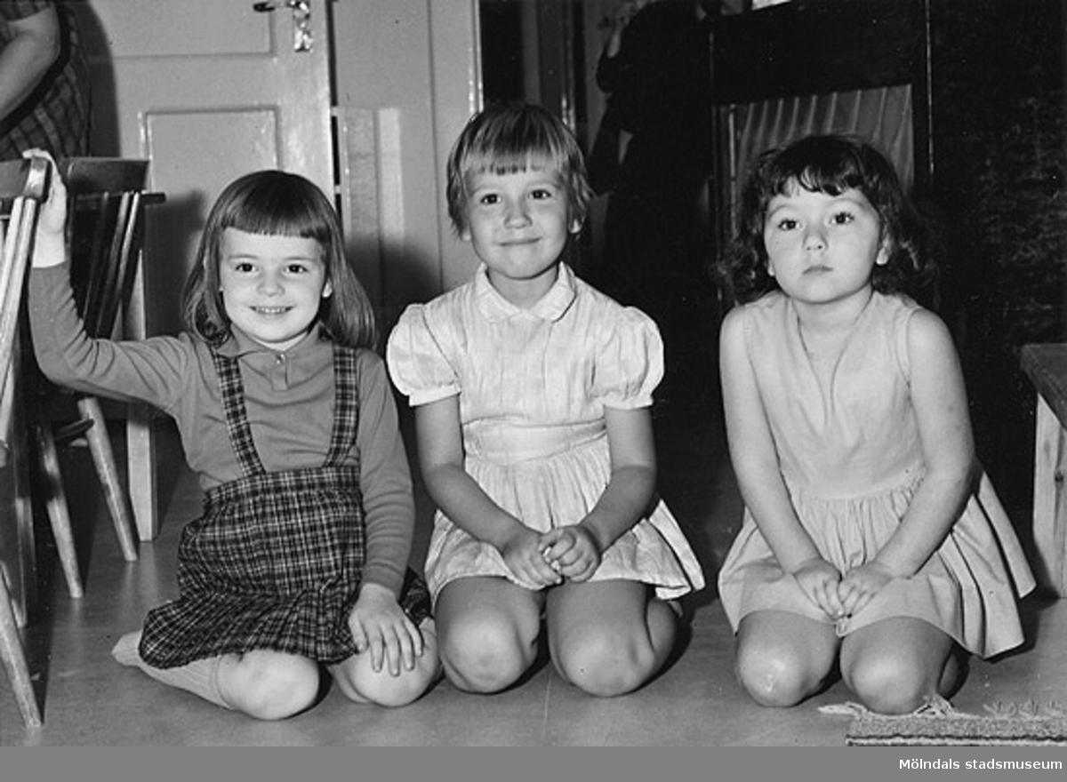 Tre flickor som sitter på golvet vid Holtermanska daghemmet 1953.