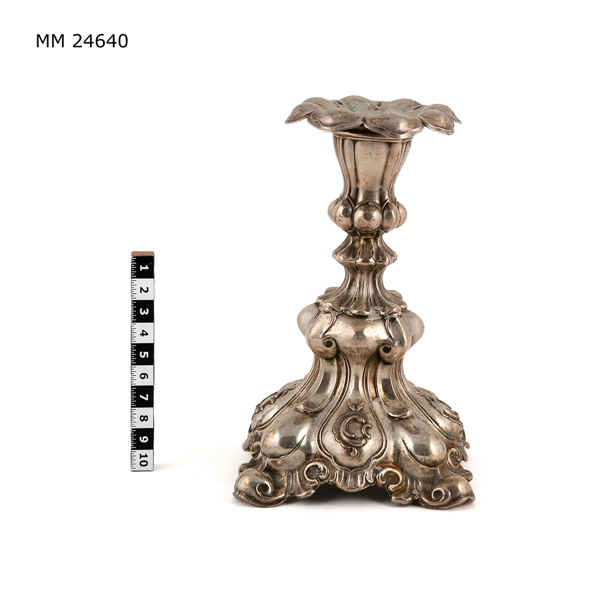 En-ljusstake av silver. Ovan foten text "Jagaren Öland från Kockums M V  A-B", till vänster om texten silverstämplar CGH V80 m fl stämplar.
