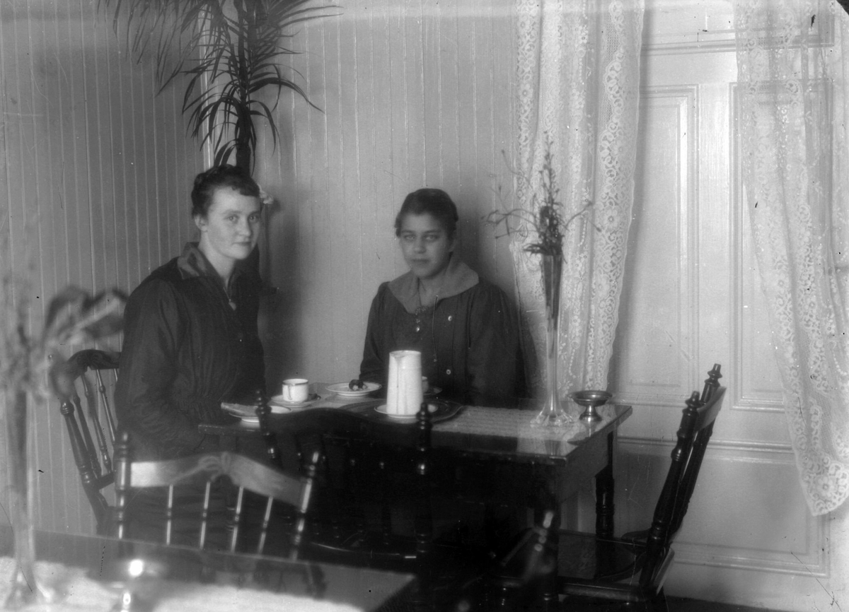 To personer som sitter ved et bord og drikker kaffe sammen.