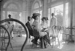 To kvinner og en mann sitter i restauranten i badehuset i Pr