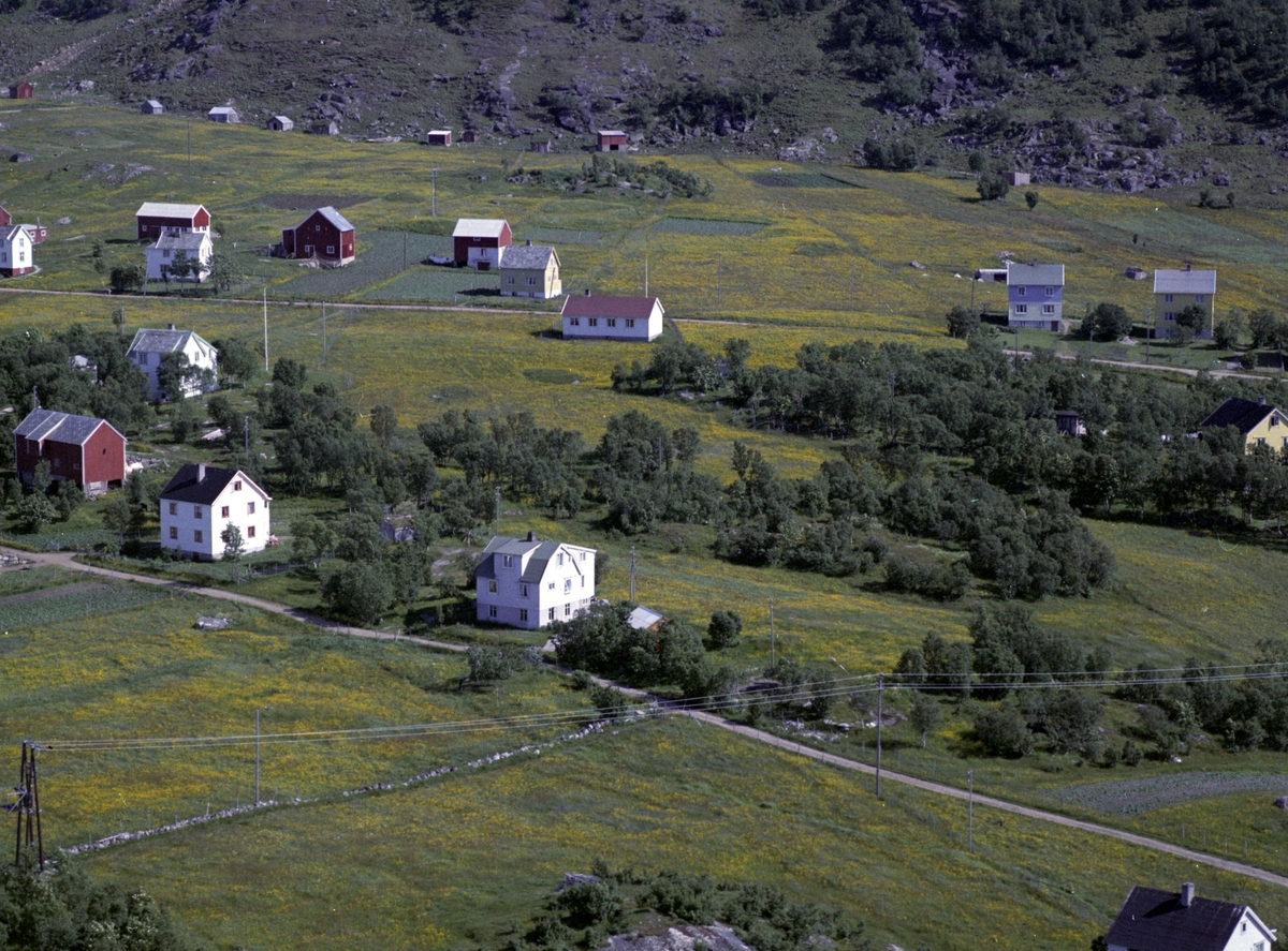 Flyfoto av bebyggelse på Grøtavær. Bedehus i midten, sommerfjøser i bakgrunnen.