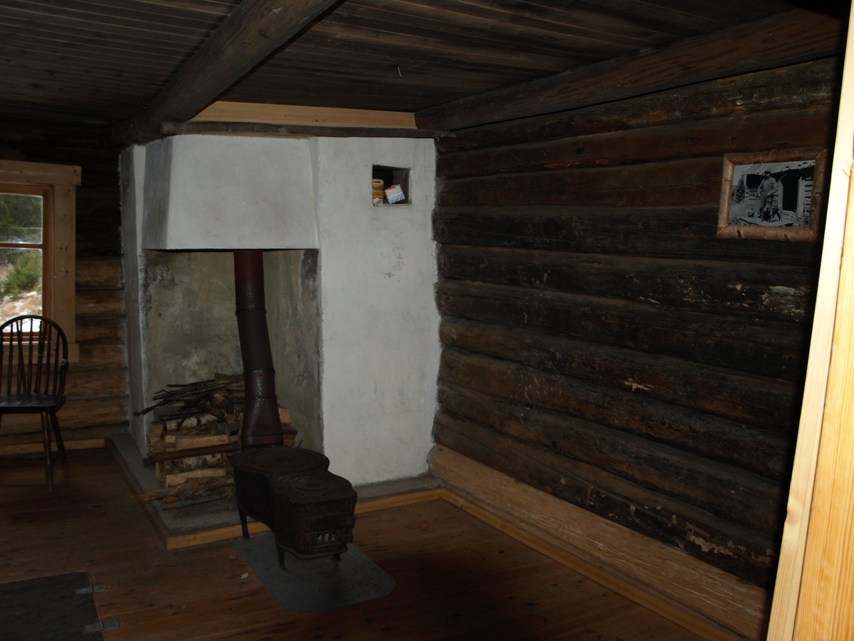 Inne i huset på Jørnehaugen finnes en skikkelig peismur, noen enkle møbler og et foto av Edvard, den siste som bodde i Fantebyen. Foto: Bodil Andersson, Østfoldmuseene/Halden historiske Samlinger.