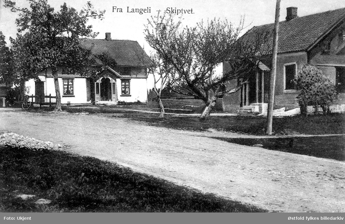 Gården Langli  i Skiptvet med våningshuset til venstre (bygget 1898) og landhandleriet til høyre under bygging. Postkort - kolorert lystrykk, stemplet 1915, tatt 1907.