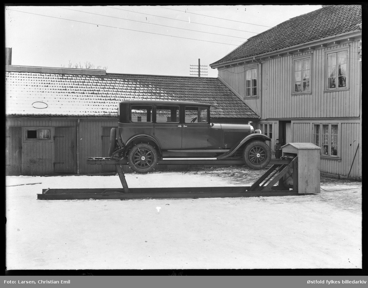 John Dahles bilverksted, bakgården til St. Marie gate 112 i Sarpsborg. Bil står på en smørebukk, ørn på panser, dekk merket Oakland, kjetting på bakhjul. Ukjent gutt.

 Bygningen til høyre er St. Mariegate 112. John Dahle hadde bilverksted her fra 1920 til 1932. Bygningen brant i 1935 og det ble satt opp nytt verksted. A/S Østlandsk Auto startet opp i de nye lokalene.(Kilde: St. Mariegate gjennom tidene).