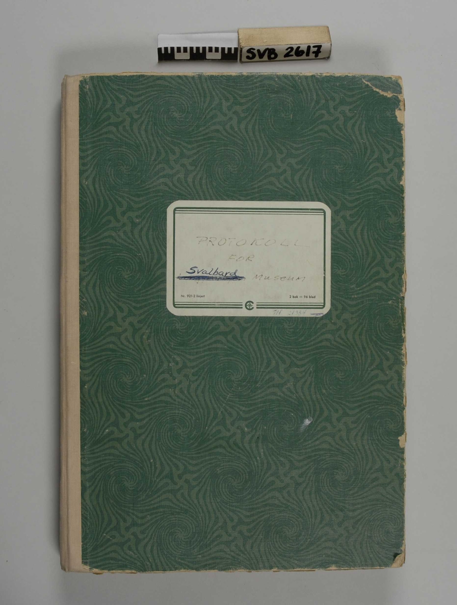 Notatbok med grønt, mønstret omslag, rygg av tekstil. Etikett på forsiden. Linjerte sider med håndskreven tekst, eller maskinskrevne ark.
