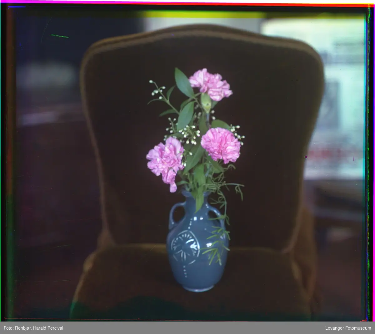 Blomster i en vase på en stol.