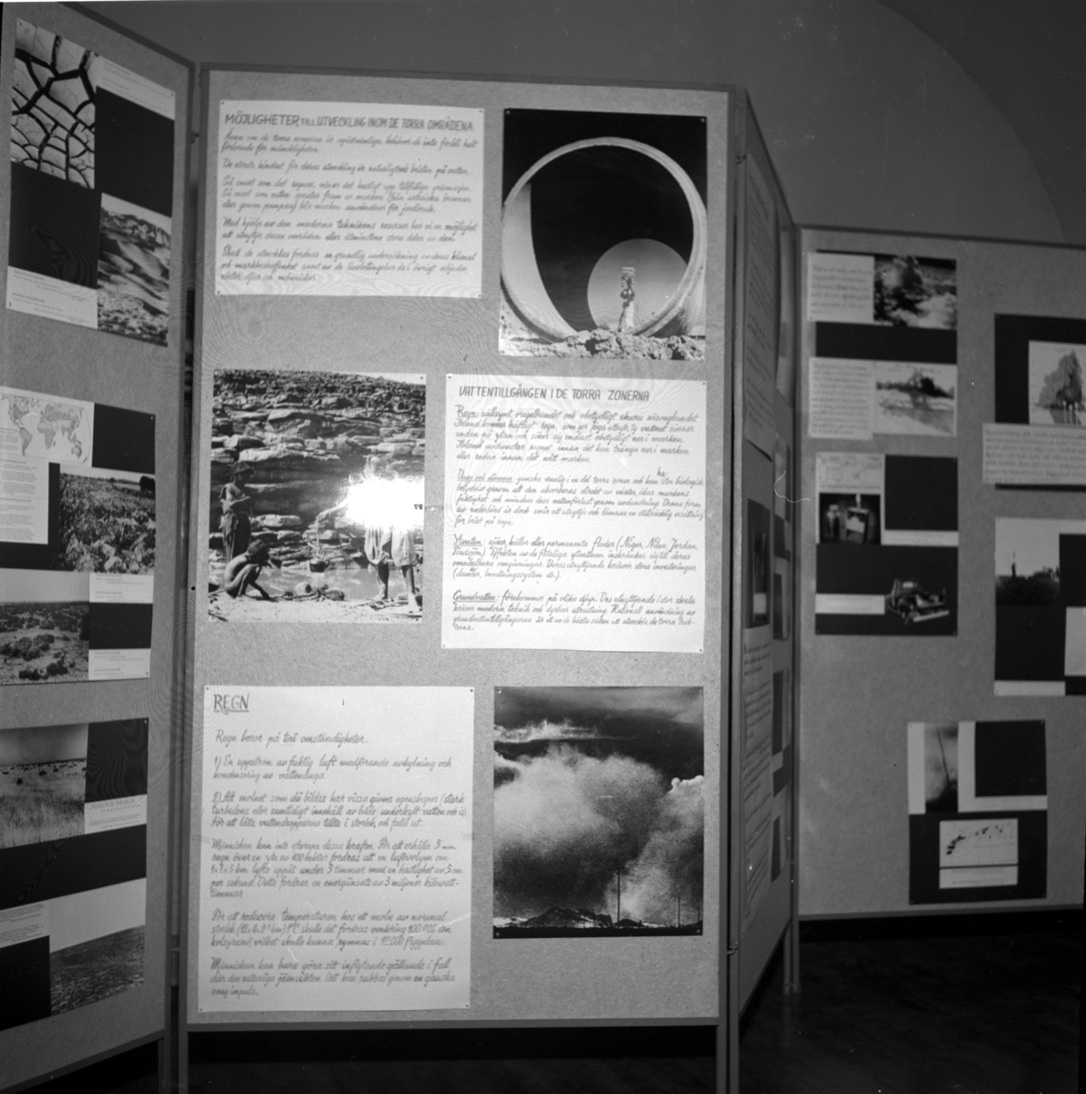 'Uställningen ''Människan och öknen - en utställning presenterad av UNESCO''. ::  :: Utställningsskärm med texter och bilder titel ''Möjligheter till utveckling inom de torra områdena'', ''Vattentillgången i de torra områdena'' och ''Regn''. ::  :: Ingår i serie med fotonr. 6984:1-18.'