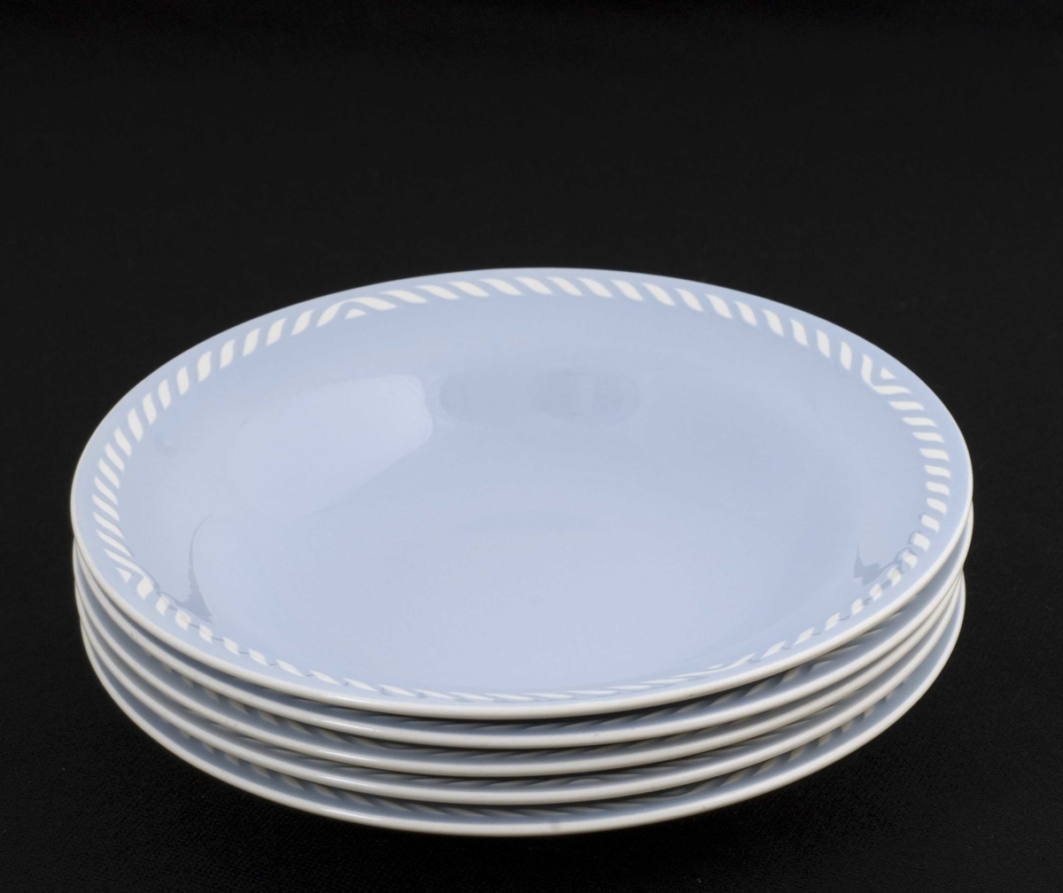 12 lyseblå tallerkener med hvit strekdekor langs kantene, hvit underside