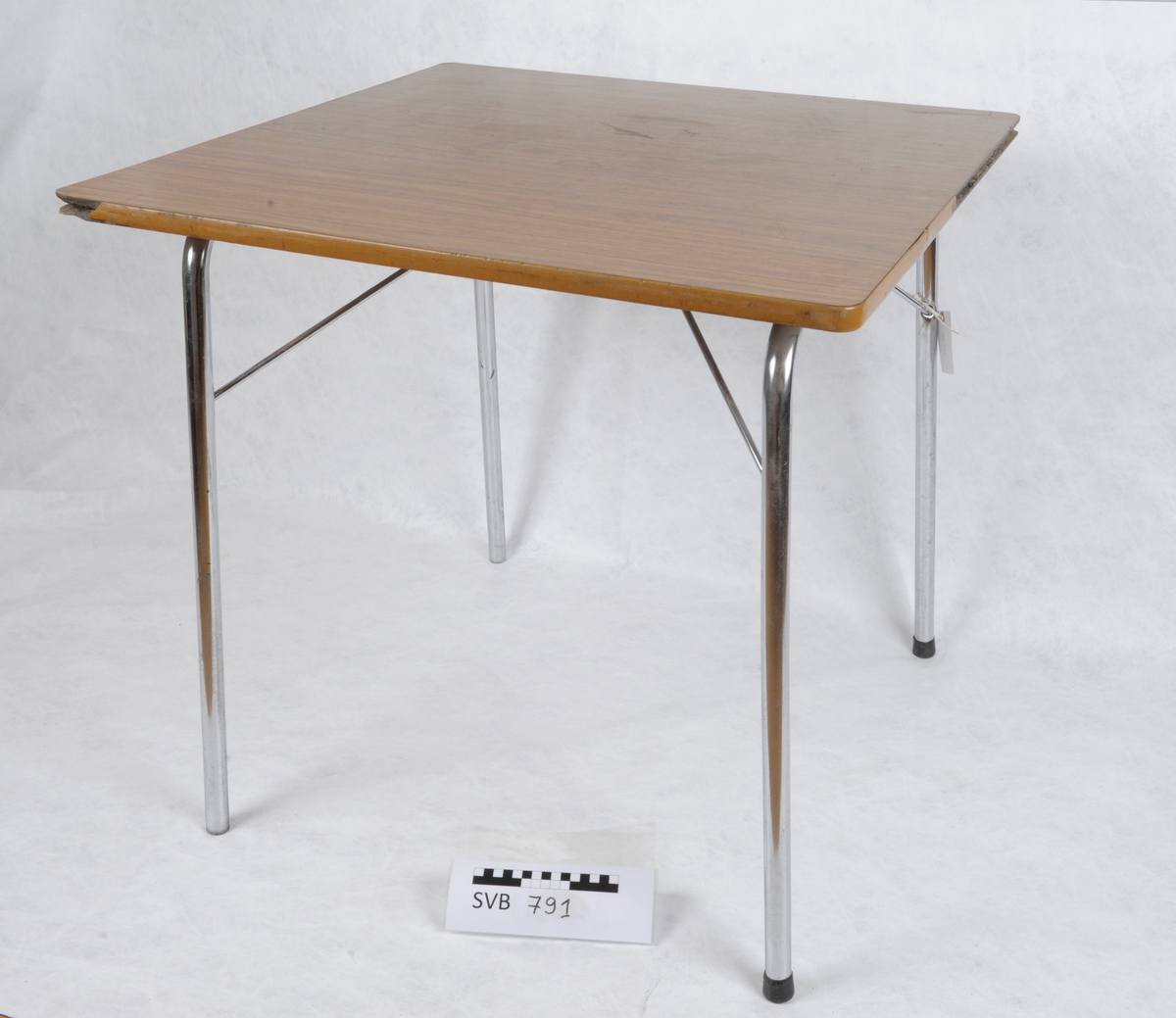Kvadratisk bord med stålbein og plate av respatex.