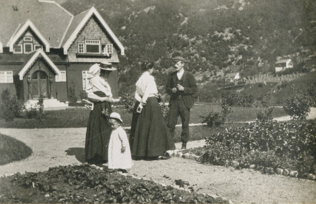 Vaksne og barn i hagen framfor Peterssons villa, "Blåsenborg".