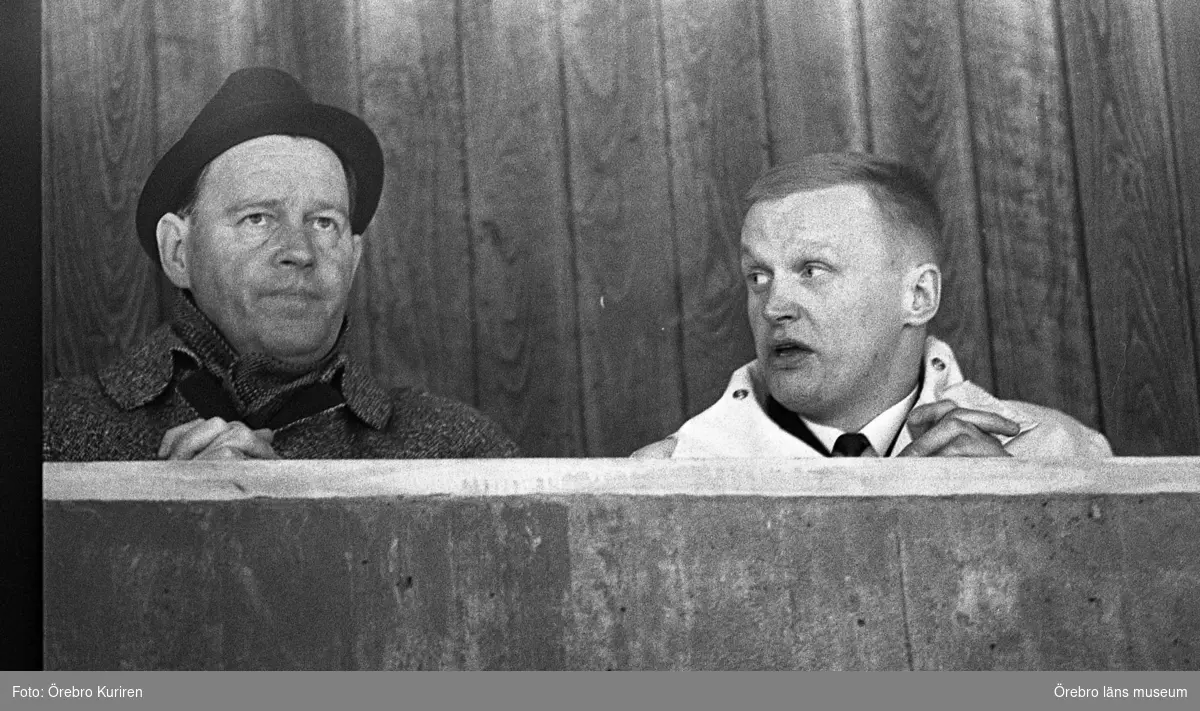 Honken, Högerkommitténs möte 25 januari 1969

Två män sitter på en läktare. Mannen till vänster på bilden har rock och hatt, och mannen till höger har skjorta och slips. Båda knäpper sina händer.