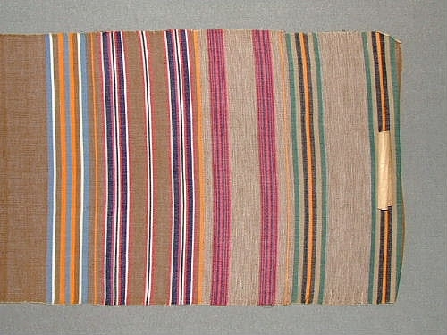Bolstervarsprov i olika randningar och olika färgställningar. Varp i bomull och inslag i ullgarn, med undantag av en bit där även inslaget är i bomull. Vävdes för en inventering på 1940-talet.