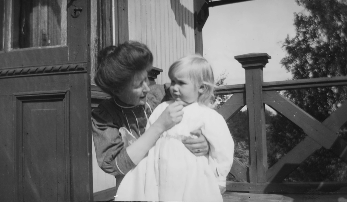 En kvinne sitter på huk og holder rundt en liten sommekledd Iacob Ihlen Mathiesen.