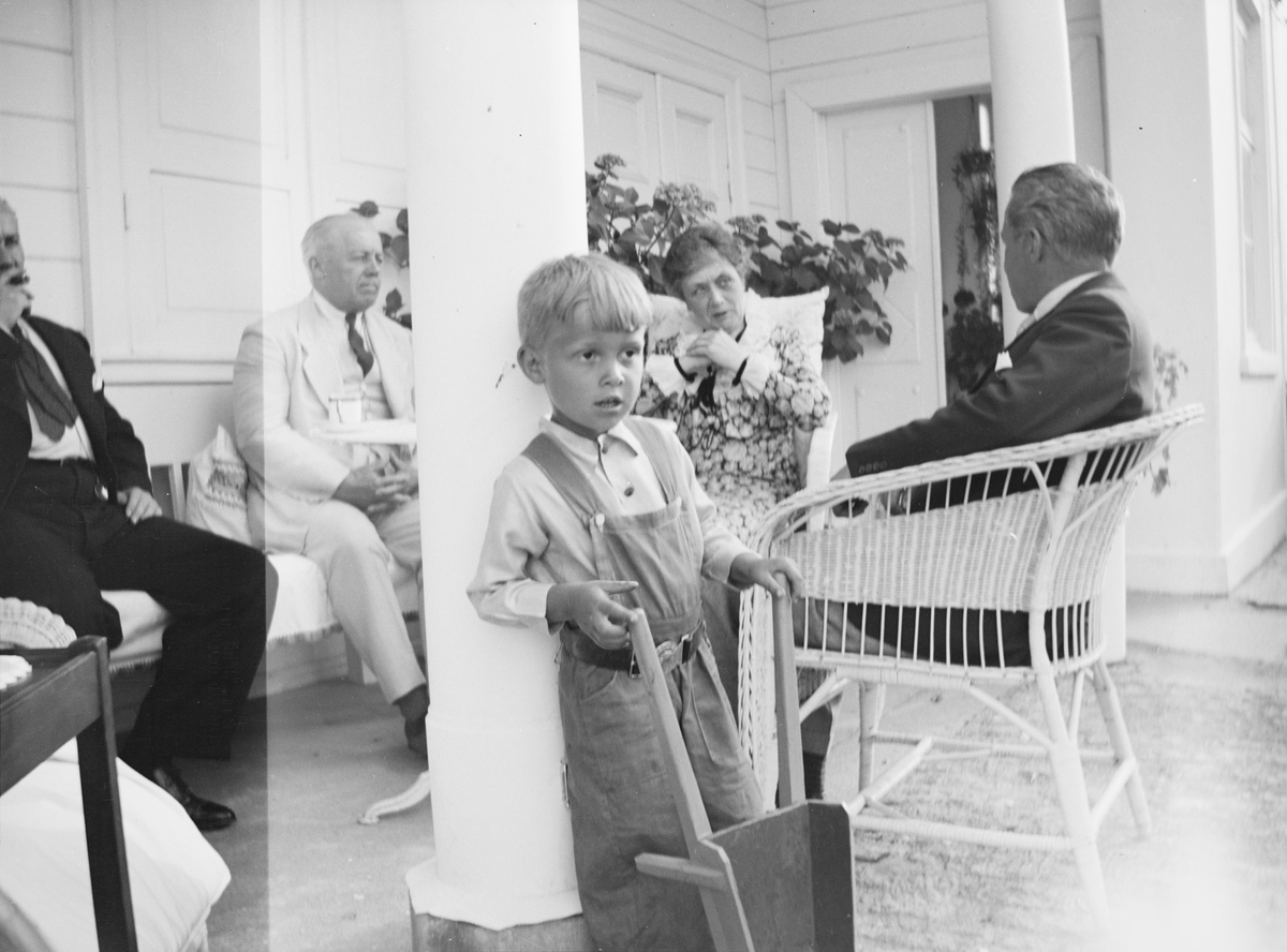 Fra venstre: Iacob Ihlen Mathiesen, statsråd Christian Pierre Mathiesen, et barnebarn, Marie Gleditsch og Haaken Christian Mathiesen sitter i svalgangen på Linderud Gård.