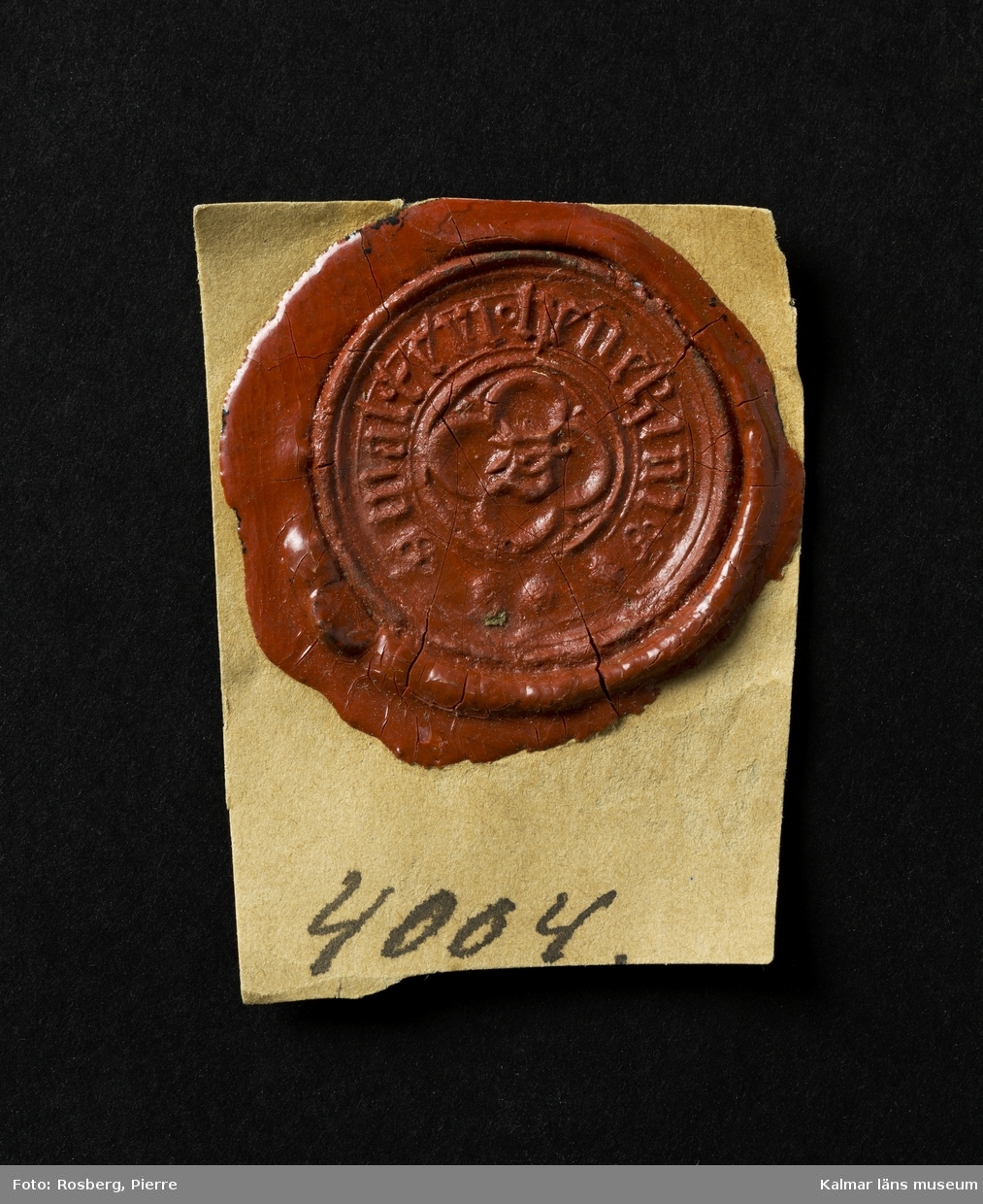 KLM 4004. Sigillstamp, berlock. Rund platta. En fyrbladig ros med omskrift, WALTERI HENEKINI. Datering, medeltid, tidigt 1400-tal.