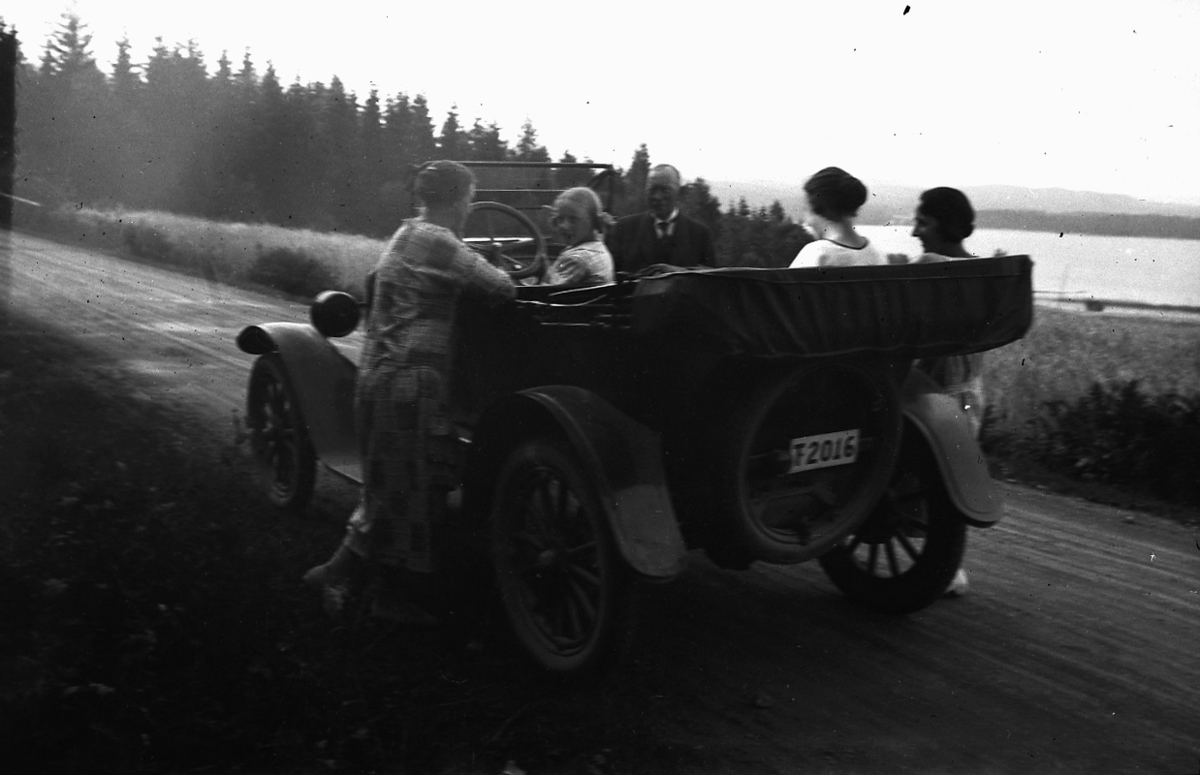 Fem personer vid en bil.
Familjen Pettersson.
Troligtvis vid sjön Usken. 
Bilen är en Overland Four som ägdes av skräddaremästare A. J. Pettersson, Lindesberg. Den hade registreringsnummer T2016 och registrerades den 25:e april 1923 med honom som ägare. År 1930 finns bilen kvar i bilregistret, men ägs numera av Viktor Teodor Johansson, Bofors.