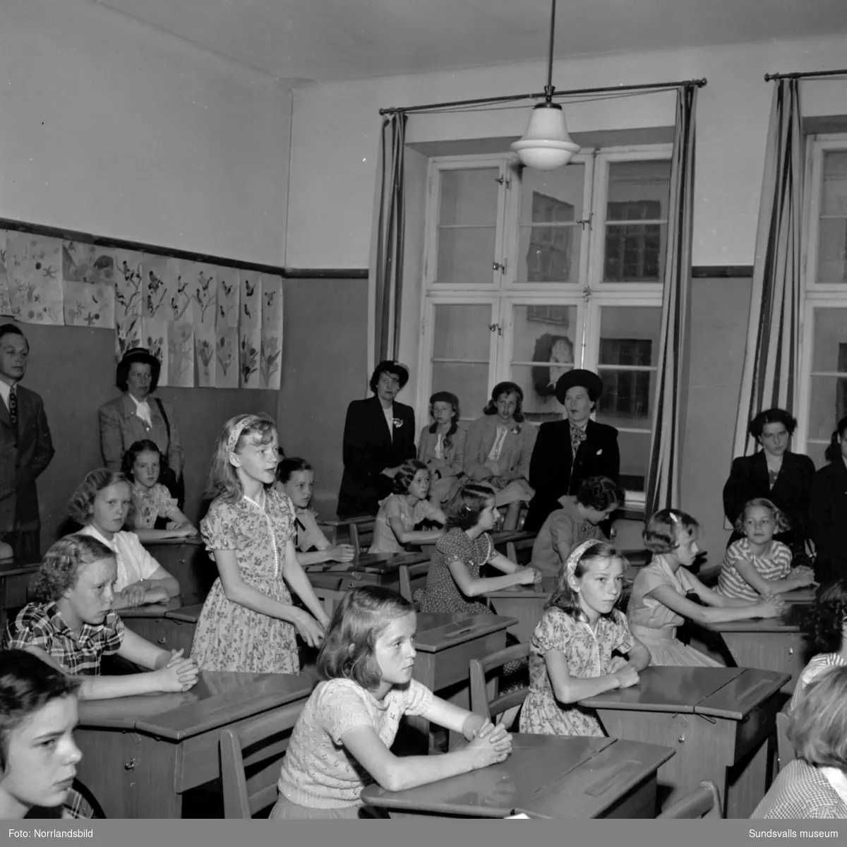 Skolavslutning på Höglundaskolan med barn, föräldrar, syskon och fröken i klassrummet.