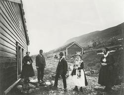 Et brudepar med brudefølge på "brudesyning" utenfor et hus p