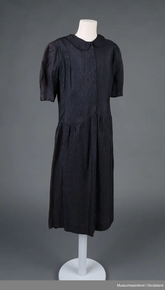 Form: korterma kjole, med rynka skjørt og patentknapping framme, rund krage
