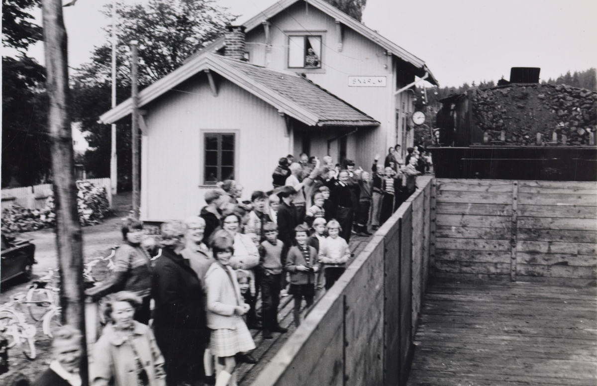 A/L Hølandsbanens veterantog til Krøderen har ankommet Snarum stasjon. Toget trekkes av damplokomotiv 18c 245. Lokalbefolkningen har møtt opp for å hilse toget velkommen.