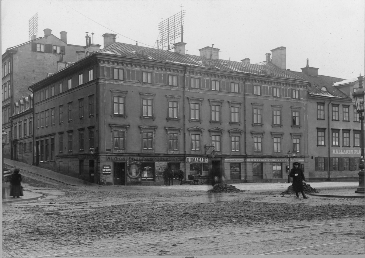 Vy från Nybrohamnen 24-26 i Stockholm  omkring 1895. Nyvarande Nybroplan-Strandvägen.  Husen troligen rivna omkring 1900. På bilden syns restaurang "Källare Flaggen", CR Feychings Jernaffär, en urmakare samt Aug. Östbergs speceriaffär.