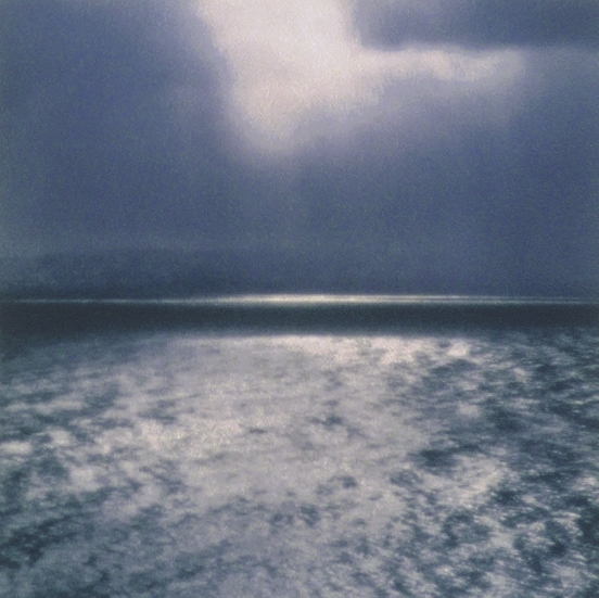 Bildet viser en mørk vinterdag, i det solen såvidt bryter frem mellom skyene. Motivet har en tematisk forankring til havet og en tilknyttning til den norske naturen.