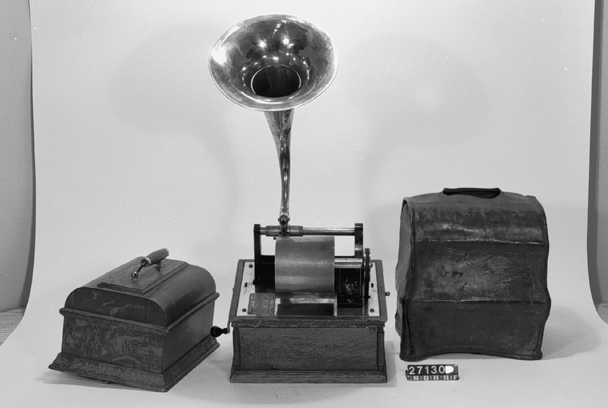 Fonograf, med svarvanordning. Avsedd för 5 tums vaxrullar, 120 varv/minut. Skylt: "The Graphophone patented May 4 1886 .... Mar 30 1897 Manufactured by the American Graphophone Company, New York, N.Y. Type HG 1216".
Tillbehör: Lösa delar: apparat, vev, ljuddosa för återgivning, ljuddosa för upptagning (båda i pappask), böjd tratt, huv av trä samt ytterhuv av brunt läder.